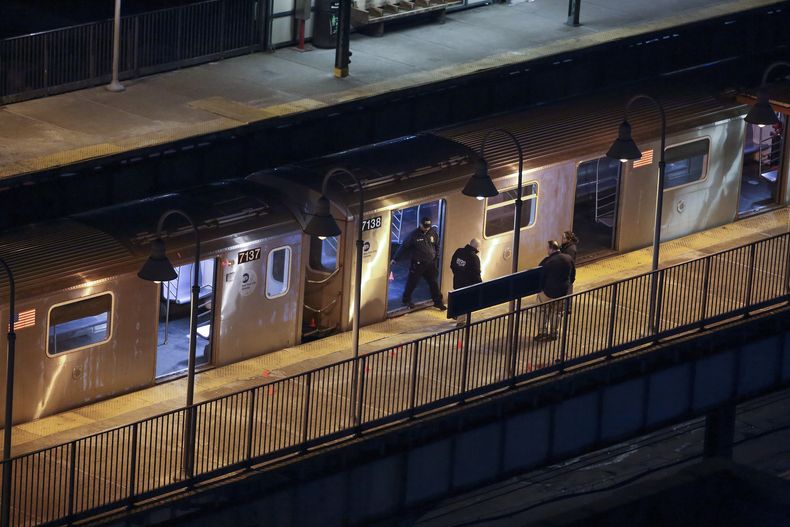 Agentes de la policía de Nueva York revisan la estación de metro Mount Eden mientras investigan un tiroteo en el sitio, el lunes 12 de febrero de 2024, en el distrito del Bronx, en Nueva York. (AP Foto/Cedar Attanasio)