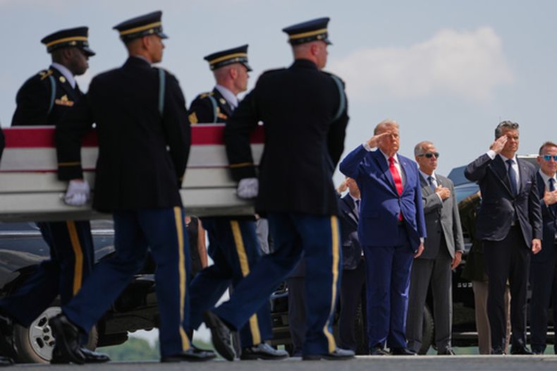 El presidente de Estados Unidos, Donald Trump, y el secretario de Defensa, Pete Hegseth, rinden homenaje mientras un equipo de transporte del ejército estadounidense traslada una caja de transferencia que contiene los restos de la soldado Isabella Gonzales de Carrollton, Texas, el miércoles 22 de julio de 2026, en la base Dover de la Fuerza Aérea, en Delaware. (AP Foto/Matt Rourke)