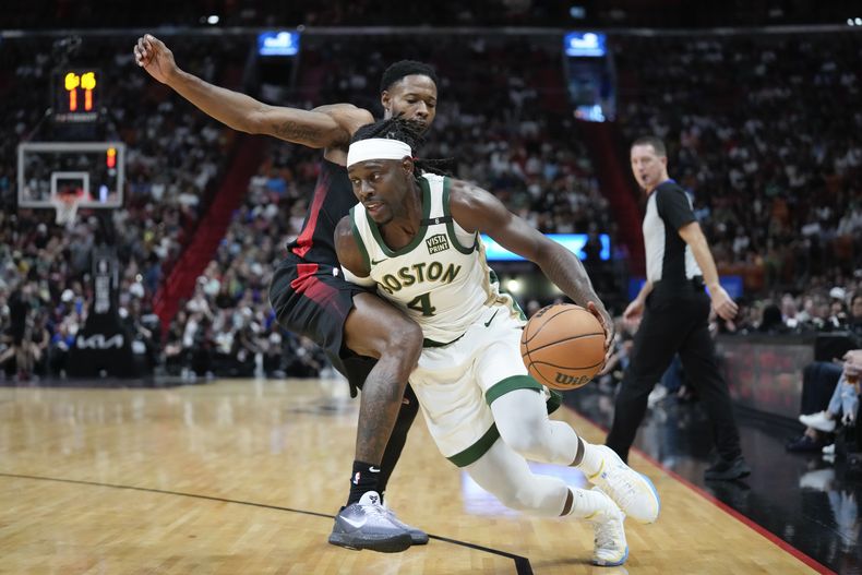 El base de los Celtics de Boston Jrue Holiday avanza hacia la canasta superando al alero del Heat de Miami Haywood Highsmith en el encuentro de la NBA del domingo 11 de febrero del 2024. (AP Foto/Rebecca Blackwell)