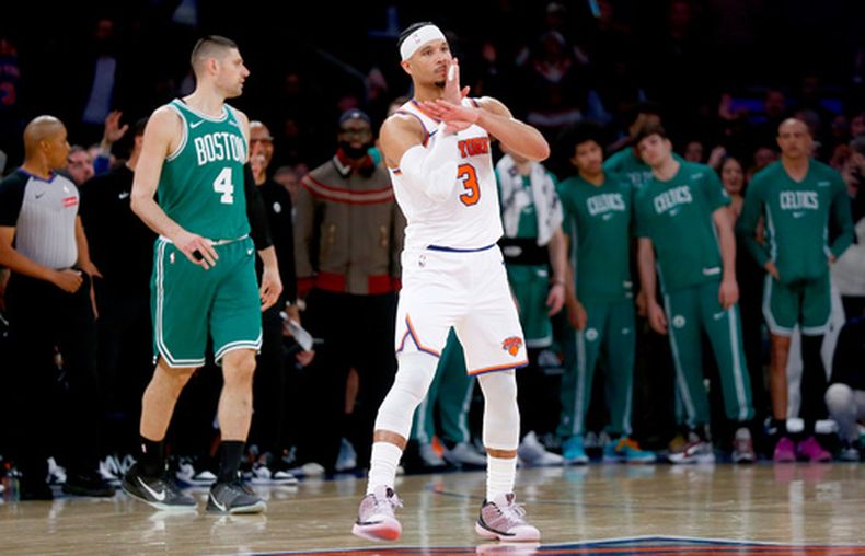 Josh Hart, de los Knicks de Nueva York, festeja luego de atinar un triple frente a Nikola Vucevic, de los Celtics de Boston, el jueves 9 de abril de 2026 (AP Foto/John Munson)