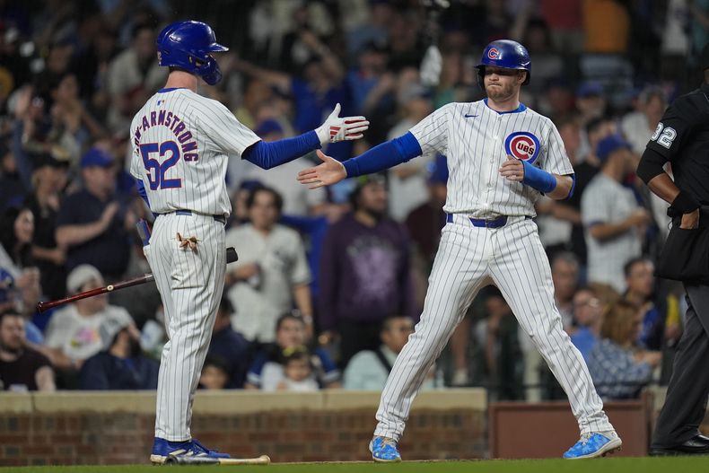 Ian Happ de los Cachorros de Chicago le da la mano a Pete Crow-Amstrong tras su doble en la quinta entrada del encuentro ante los Medias Blancas de Chicago el martes 4 de junio del 2024. (AP Foto/Erin Hooley)