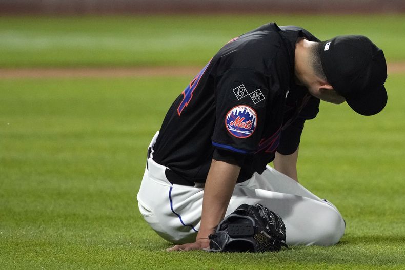 Kodai Senga de los Mets de Nueva York se tira al suelo tras lesionarse en la sexta entrada del encuentro ante los Bravos de Atlanta el viernes 26 de julio del 2024. (AP Foto/Pamela Smith)