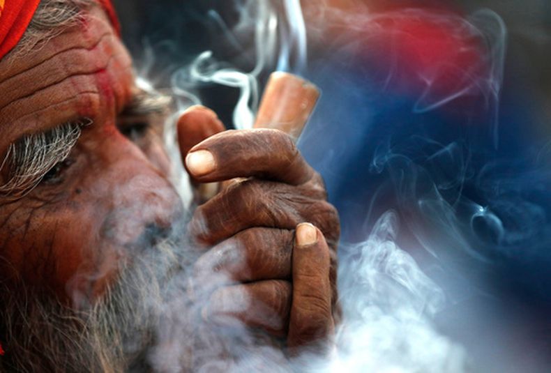 ARCHIVO - En esta imagen, tomada el 11 de marzo de 2021, un hombre santo hindú fuma marihuana en el patio del templo Pashupatinath durante el festival Shivratri en Katmandú, Nepal. (AP Foto/Niranjan Shrestha, archivo)