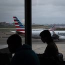 Gente esperando a vuelos mientras un avión de American Airlines circula por la pista en el aeropuerto LaGuardia (LGA) en el barrio de Queens, Nueva York, el domingo 9 de noviembre de 2025. (AP Foto/Adam Gray)