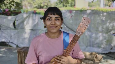 La activista y actriz afromexicana Eréndira Castorela posa para una foto con su instrumento, una jarana jarocha, durante un descanso de los ensayos de Mulato Teatro, en Tucumán, México, el 17 de mayo de 2025. (AP Foto/Ginnette Riquelme)