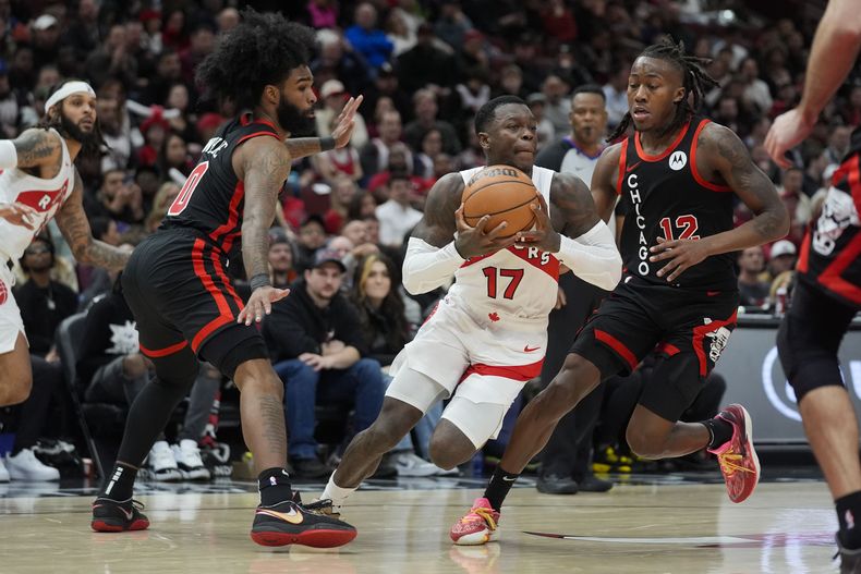 El escolta de los Bulls de Chicago, Coby White, a la izquierda, y el escolta Ayo Dosunmu (12), de los Raptors de Toronto, Dennis Schroder (17), durante la segunda mitad deL partido de baloncesto de la NBA, el martes 30 de enero de 2024, en Chicago. Toronto ganó 118-107. (AP Foto/Erin Hooley)