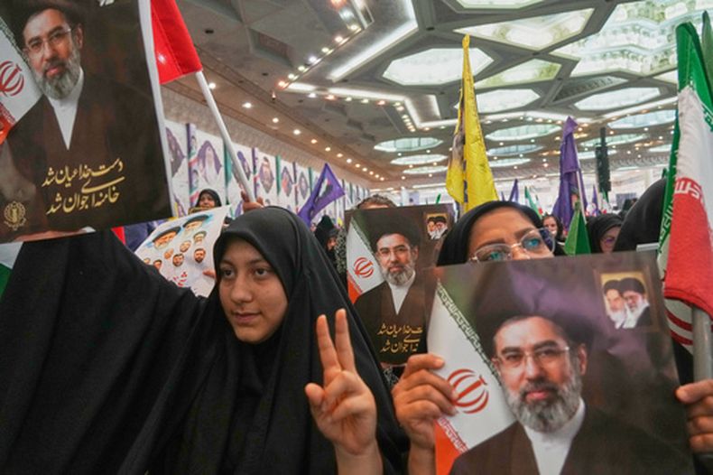 Mujeres sostienen retratos del líder supremo de Irán, Moytaba Jamenei, durante una ceremonia en homenaje a fuerzas armadas y los caídos en la guerra con Israel y Estados Unidos, en la Gran Mezquita Imán Jomeini en Teherán, Irán, el domingo 24 de mayo de 2026. (AP Foto/Vahid Salemi)