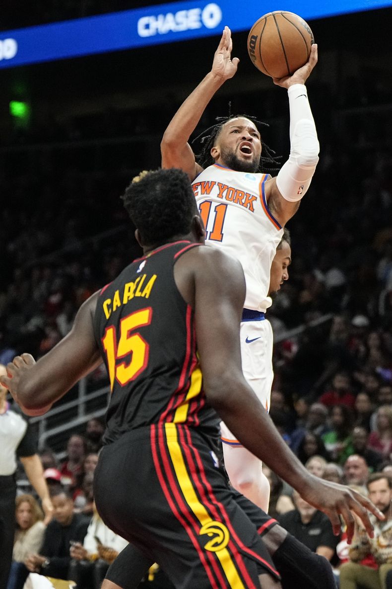 Jalen Brunson, base de los Knicks de Nueva York, dispara frente a Clint Capela, pívot de los Hawks de Atlanta, en el encuentro del viernes 27 de octubre de 2023 (AP Foto/Mike Stewart)