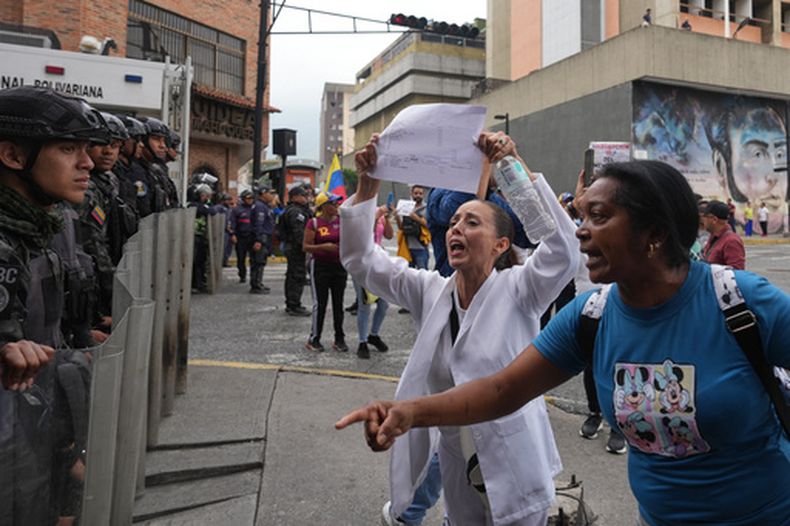 Las fuerzas de seguridad impiden a trabajadores públicos y pensionistas llegar al palacio presidencial durante una protesta por mejores salarios y derechos laborales en Caracas, Venezuela, el martes 13 de octubre de 2026. (Foto AP/Ariana Cubillos)