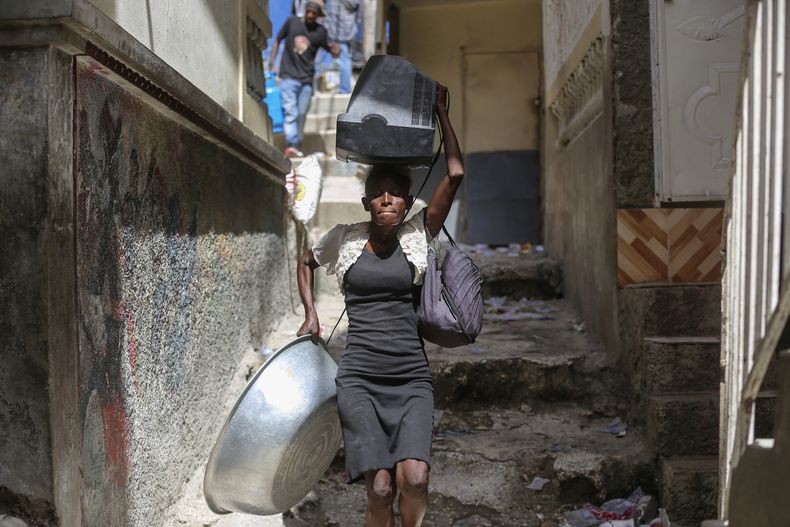 Residentes huyen de sus casas para escapar de los enfrentamientos entre pandillas armadas en el distrito de Carrefout-Feuilles, el martes 15 de agosto de 2023, en Puerto Príncipe, Haití. (AP Foto/Odelyn Joseph)