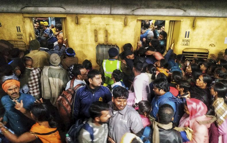 Pasajeros se empujan para abordar un tren en la estación de Nueva Delhi, India, el sábado 15 de febrero de 2025. (AP Foto)