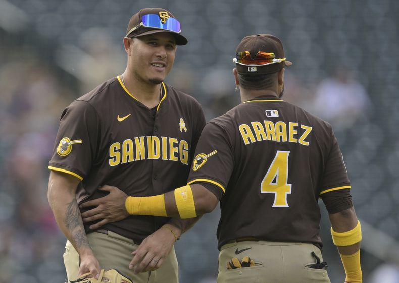 El tercera base de los Padres de San Diego, el dominicano Manny Machado, a la izquierda, y el primera base venezolano Luis Arráez (4) celebran después de un juego de béisbol contra los Rockies de Colorado, el domingo 7 de septiembre de 2025, en Denver. (AP Photo/RJ Sangosti)