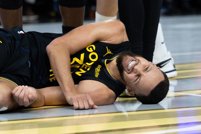 Stephen Curry, base de los Warriors de Golden State, yace en la cancha durante el partido ante los Rockets de Houston, el miércoles 26 de noviembre de 2025 (AP Foto/Benjamin Fanjoy)