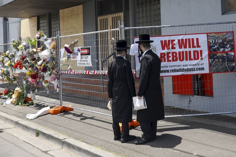 Gente reunida ante la sinagoga Adass Israel, dañada por un incendio provocado en Melbourne, el lunes 9 de diciembre de 2024. (Con Chronis/AAP Image via AP)