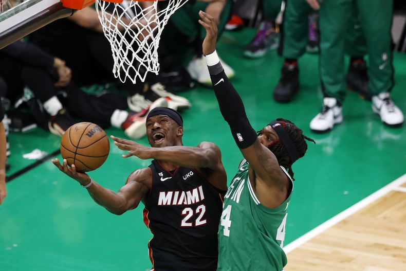 El alero del Heat de Miami Jimmy Butler lanza el balón sobre el pívot de los Celtics de Boston Robert Williams III en el juego 7 de las finales de la Conferencia Este el lunes 29 de mayo del 2023. (AP Foto/Michael Dwyer)