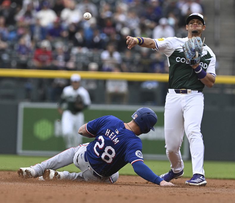 El venezolano Ezequiel Tovar, de los Rockies de Colorado, tira a primera tras poner out a Jonah Heim, de los Rangers de Texas, el sábado 11 de mayo de 2024 (AP Foto/Jerilee Bennett)