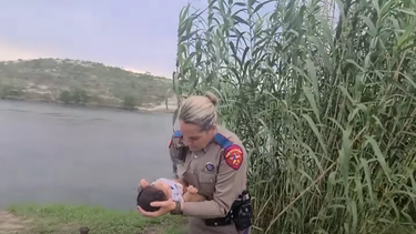 conmovedoras imagenes de una policia de la frontera en eeuu carga a una bebe venezolana mientras su madre cruza rio grande