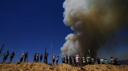 ARCHIVO - Residentes miran una columna de humo que asciende hacia el cielo, en Viña del Mar, Chile, el 3 de febrero de 2024. Científicos afirman que el cambio climático crea condiciones que elevan el riesgo de sequías e incendios forestales como los que ahora golpean al país sudamericano. (AP Foto/Esteban Félix, Archivo)