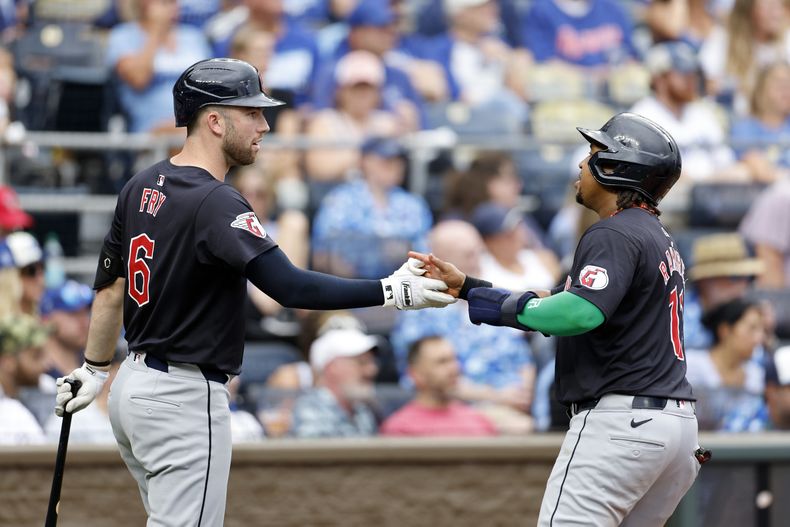 El dominicano José Ramírez (derecha), de los Guardianes de Cleveland, es felicitado por David Fry, luego de anotar una carrera ante los Reales de Kansas City, el sábado 29 de junio de 2024 (AP Foto/Colin E. Braley)