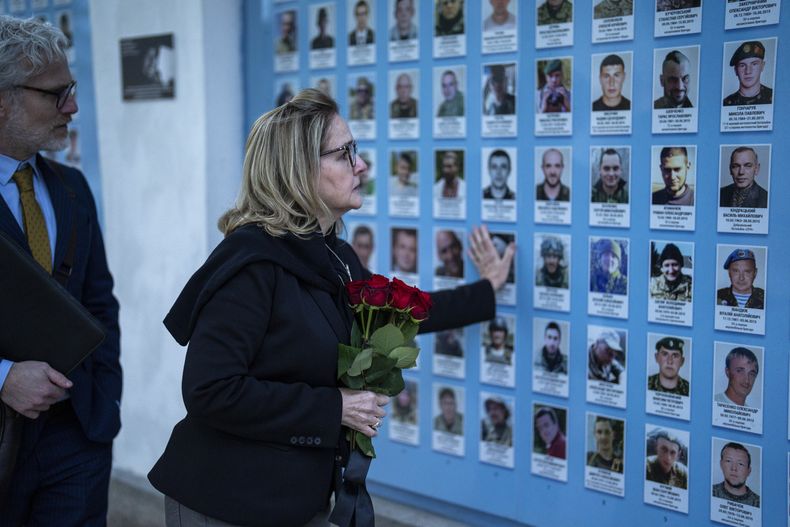 La congresista estadounidense, Madeleine Deane, demócrata por Pensilvania, coloca flores en un muro conmemorativo para los soldados ucranianos muertos durante la guerra en la catedral de San Miguel en Kiev, Ucrania, el lunes 22 de abril de 2024. (Foto AP/Francisco Seco)