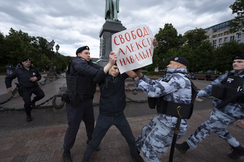 Agentes de la policía detienen a un manifestante que sostiene un letrero que dice: Libertad para Alexei Navalny, en referencia al líder opositor encarcelado, el domingo 4 de junio de 2023, en Moscú, Rusia. (AP Foto)
