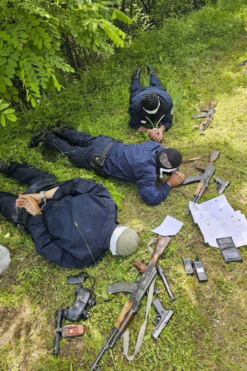En esta imagen proporcionada por el Ministerio serbio del Interior, tres policías de Kosovo capturados por policías serbios se ven tumbados boca abajo en un campo, el miércoles 14 de junio de 2023. Las autoridades serbias dijeron el miércoles que habían capturado a tres policías totalmente armados en Serbia cerca de la frontera, mientras que la policía de Kosovo dijo que probablemente habían sido secuestrados en territorio kosovar cuando patrullaban la zona. (Ministerio serbio del Interior via AP)
