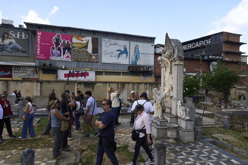 Visitantes realizan un recorrido guiado al histórico Cementerio General del Sur, donde algunas tumbas se encuentran en desorden, en Caracas, Venezuela, el domingo 6 de julio de 2025. (Foto AP/Ariana Cubillos)
