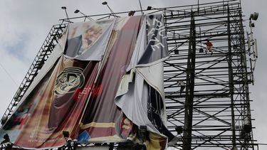 americateve | Trabajadores retiran una enorme valla publicitaria junto a una autopista como parte de los preparativos para los posibles efectos del poderoso tif&oacute;n Haiyan en Makati, al sur de Manila, Filipinas, el jueves 7 de noviembre de 2013. (Foto AP/Aaron Fav