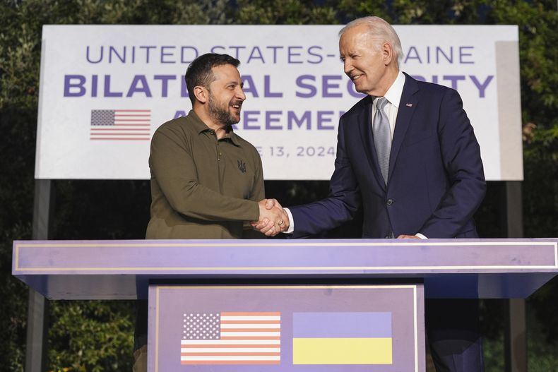 ARCHIVO - El presidente de Estados Unidos, Joe Biden, y el presidente de Ucrania, Volodymyr Zelenskyy, estrechan la mano tras firmar un acuerdo de seguridad en un aparte del G7 el jueves 13 de junio de 2024 en Savelletri, Italia. (AP Foto/Alex Brandon, Archivo)