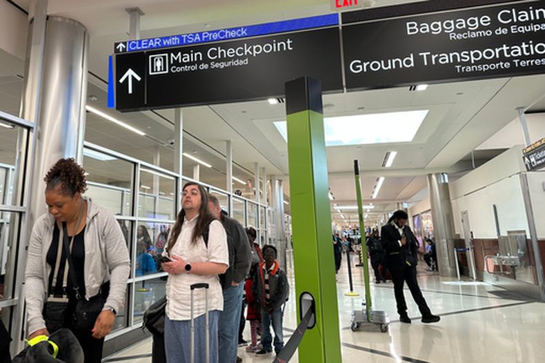 Varios pasajeros esperan fuera de un punto de control de la Administración Seguridad en el Transporte (TSA, por sus siglas en inglés) en el Aeropuerto Internacional Hartsfield-Jackson de Atlanta el sábado 21 de marzo de 2026, (AP Foto/Jeff Amy)