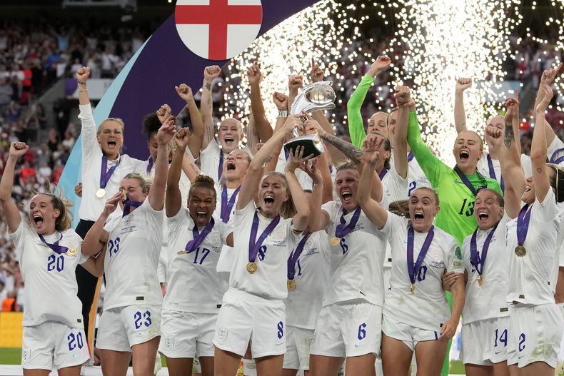 ARCHIVO - Foto del 31 de julio del 2022, las inglesas Leah Williamson y Millie Bright sostienen el trofeo tras ganar la Euro femenina 2022 al vencer a Alemania en Wembley. (AP Foto/Alessandra Tarantino, Archivo)