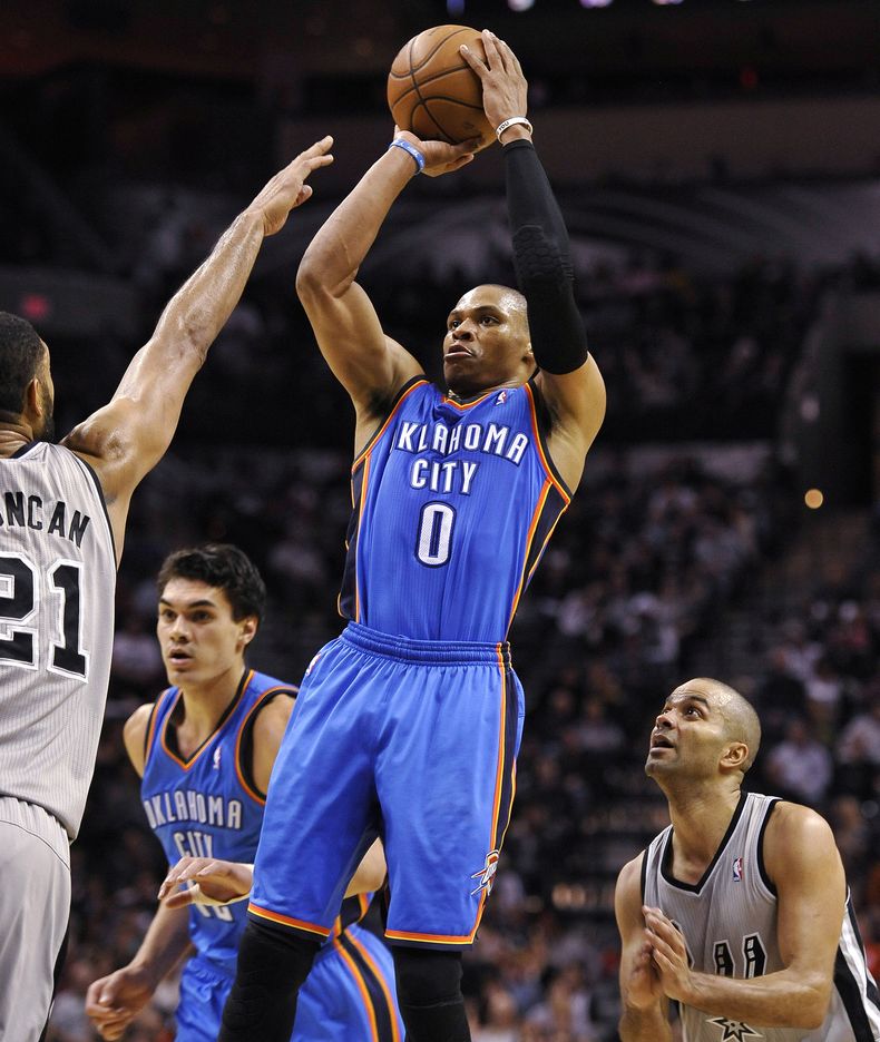 Russell Westbrook, centro, del Thunder de Oklahoma City, dispara en medio de Tim Duncan, izquierda, y el franc&eacute;s Tony Parker, de los Spurs de San Antonio, en acciones de la segunda mitad del partido de la NBA disputado el s&aacute;bado 21 de diciem