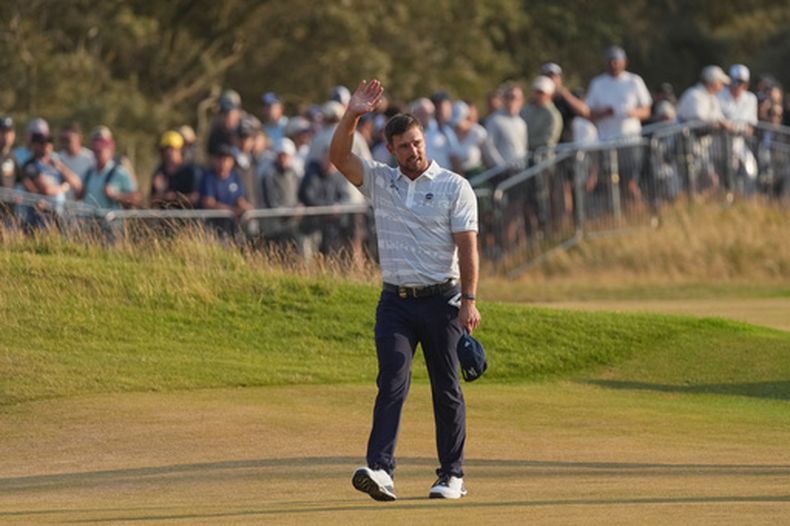 Bryson DeChambeau, de Estados Unidos, saluda a los fanáticos mientras camina al hoyo 18 durante el tercer día de actividad del Abierto Británido de Golf, en el campo del club de golf en Royal Birkdale, el sábado 18 de julio de 2026, en Southport, Inglaterra. (AP Foto/Jon Super)