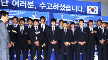 americateve | En esta foto del 30 de junio de 2014, los jugadores de la selecci&oacute;n surcoreana observan a un grupo de hinchas que les lanzan dulces tradicionales, un insulto, a su regreso del Mundial, en el que fueron eliminados en la primera fase (AP Foto/Yonhap,