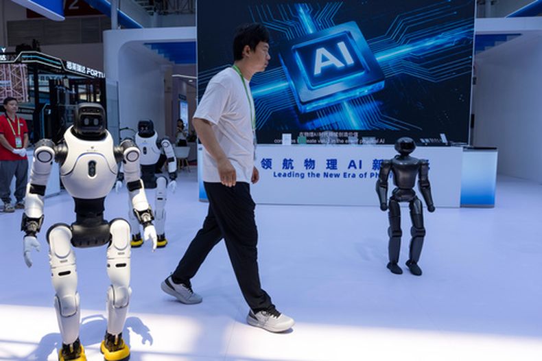 ARCHIVO - Un trabajador pasa junto a robots de la empresa china Lens en el China International Supply Chain Expo en Beijing, el 22 de junio de 2026. (AP Photo/Ng Han Guan, archivo)
