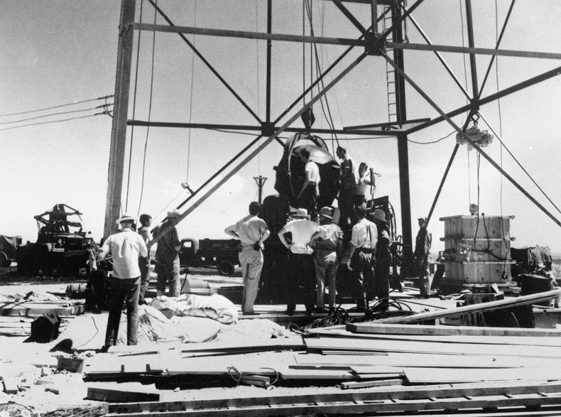 ARCHIVO - Científicos y otros trabajadores manipulan la primera bomba atómica del mundo para levantarla sobre una torre de 100 pies en el sitio de prueba Trinity cerca de Alamagordo, Nuevo México una nueva película sobre la vida de J. Robert Oppenheimer y su papel en el desarrollo de la bomba atómica como parte del Proyecto Manhattan durante la Segunda Guerra Mundial se estrena en cines el 21 de julio de 2023. en Nuevo México todavía hay residentes que viven con las consecuencias de esta prueba. (Foto AP/archivo)