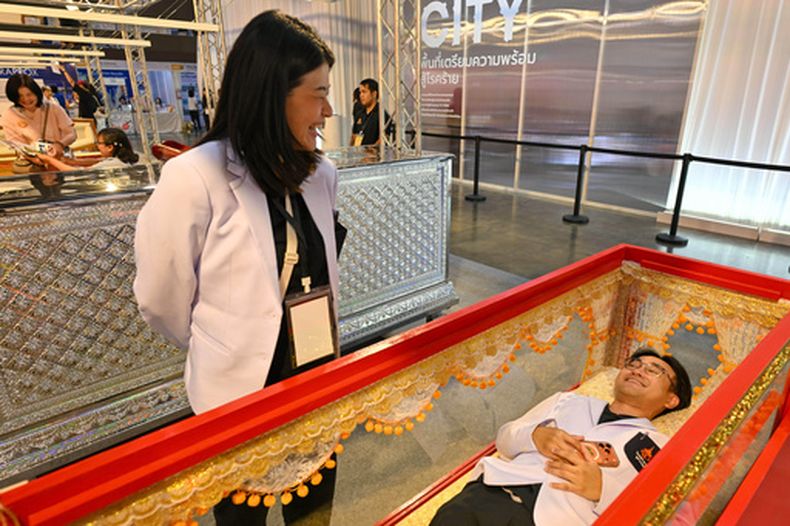 Una persona prueba un féretro en la Feria de la Muerte en Nonthaburi, Tailandia, el 13 de marzo del 2026. (AP foto/Kittinun Rodsupan)