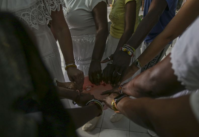 Santeras y feligreses de la tradición afrocubana realizan una celebración espiritual por la salud del papa Francisco en un salón de la Asociación Cultural Yoruba de Cuba, en La Habana, el sábado 1 de marzo de 2025. (AP Foto/Ariel Ley)