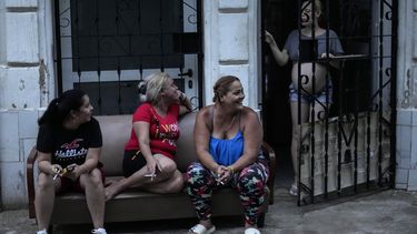Varias mujeres pasan el tiempo fuera de casa durante el apagón masivo en el que derivó la caída en el funcionamiento de una de las mayores plantas termoeléctricas del país, en La Habana, Cuba, el viernes 18 de octubre de 2024. (AP Foto/Ramón Espinosa)