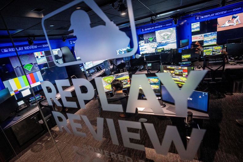 ARCHIVO - Un empleado trabaja en un puesto de apoyo dentro de la sala de revisión de repeticiones en la sede de las Grandes Ligas de Béisbol (MLB) en Nueva York, el martes 28 de marzo de 2023. (AP Photo/John Minchillo, Archivo)