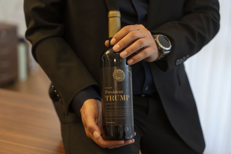 Israel Ganz, presidente del consejo de colonos de Yesha y jefe del Consejo Regional de Mateh Binyamin, muestra una botella de vino con el nombre del presidente electo de EEUU, Donald Trump, en el Parque Industrial Shaar Binyamin en Cisjordania, el 11 de noviembre de 2024. (AP Foto/Ohad Zwigenberg)