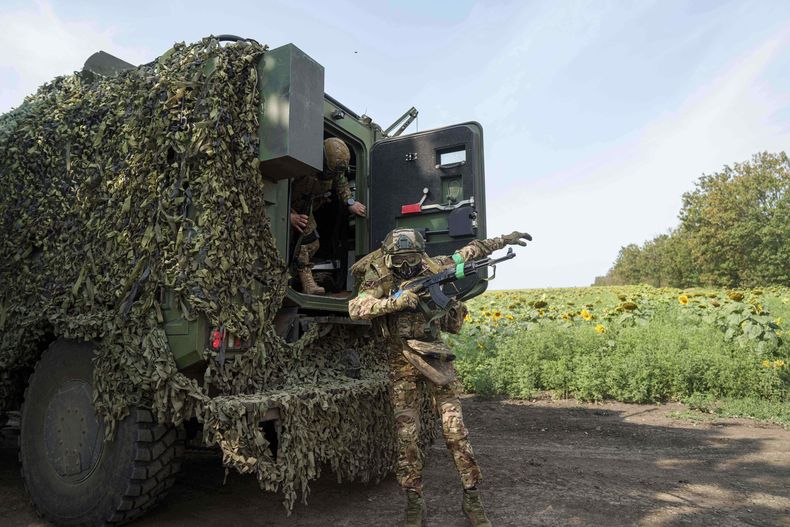 Un miembro de la Guardia Nacional Ucraniana de la 3ra brigada «Spartan» salta de un vehículo blindado durante un entrenamiento cerca del frente en dirección a Pokrovsk, Ucrania, el viernes 8 de agosto de 2025. (AP Foto/Evgeniy Maloletka)