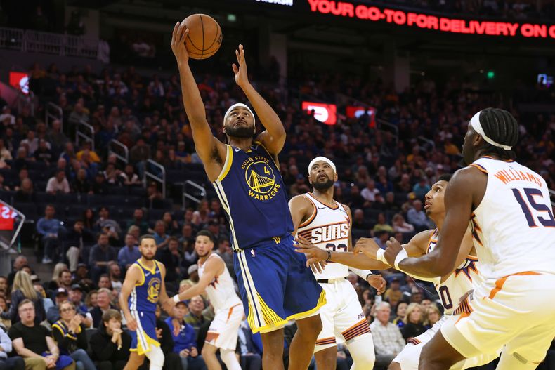 Moses Moody, de los Warriors de Golden State, dispara frente a Mark Williams, de los Suns de Phoenix, el martes 4 de noviembre de 2025 (AP Foto/Jed Jacobsohn)