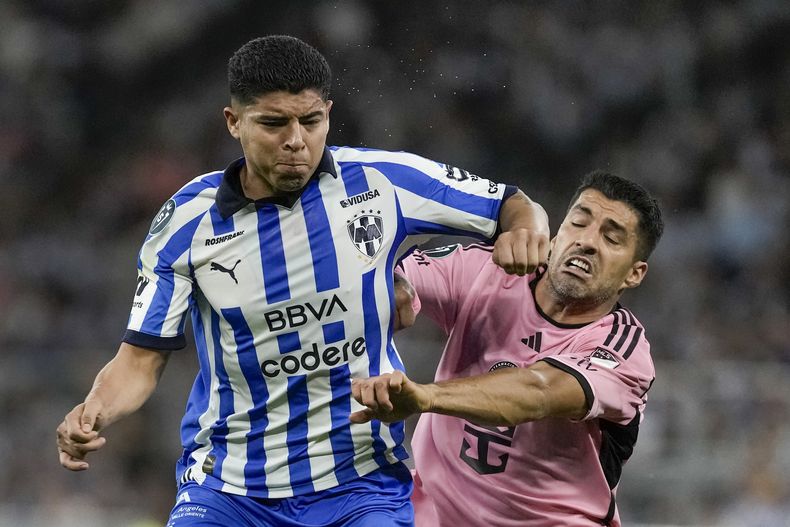 Víctor Guzmán, del Monterrey, y el uruguayo Luis Suárez, del Inter Miami, disputan un balón en un partido de la Copa de Campeones de la CONCACAF, el miércoles 10 de abril de 2024 (AP Foto/Eduardo Verdugo)