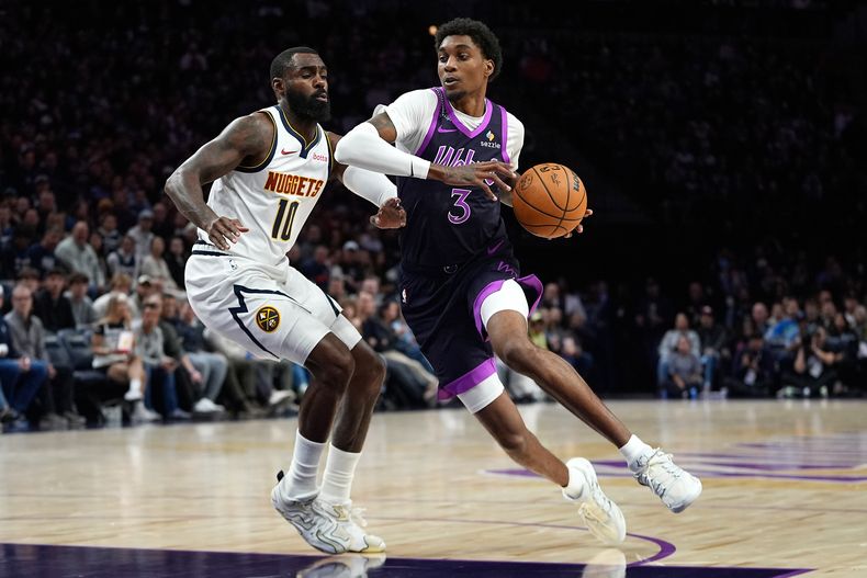 Jaden McDaniels (3), alero de los Timberwolves de Minnesota, avanza hacia la canasta mientras Tim Hardaway Jr. (10), base de los Nuggets de Denver, defiende durante la primera mitad de un juego de baloncesto de la NBA, el sábado 15 de noviembre de 2025, en Minneapolis. (AP Photo/Abbie Parr)