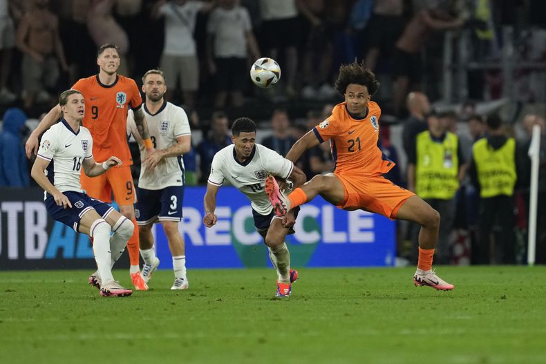 El holandés Joshua Zirkzee pelea por el balón con el inglés Jude Bellingham en el duelo de semifinales de la Euro 2024 el miércoles 10 de julio del 2024. (AP Foto/Darko Vojinovic)