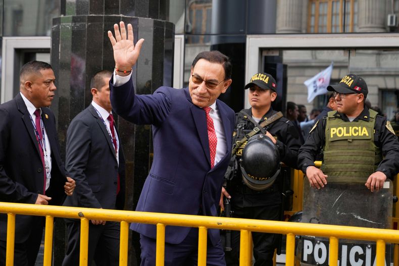 El expresidente Martín Vizcarra, quien enfrenta cargos de corrupción, saluda al llegar a una audiencia de sentencia en Lima, Perú, el miércoles 26 de noviembre de 2025. (AP Foto/Martín Mejía)