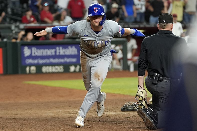 Nico Hoerner, de los Cachorros de Chicago, anota en un wild pitch en el noveno inning del juego de la MLB que enfrentó a su equipo con los Diamondbacks de Arizona, el 15 de abril de 2024, en Phoenix. (AP Foto/Matt York)
