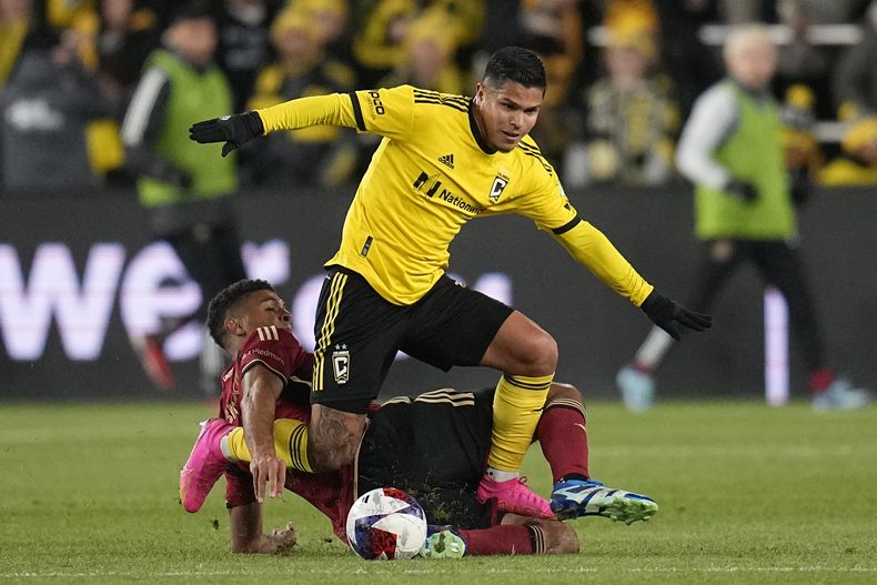 El colombiano Cucho Hernández, del Crew de Columbus, avanza pese a la barrida de Miles Robinson, del Atlanta United, en el encuentro de playoffs realizado el miércoles 1 de noviembre de 2023 en la MLS (AP foto/Sue Ogrocki)