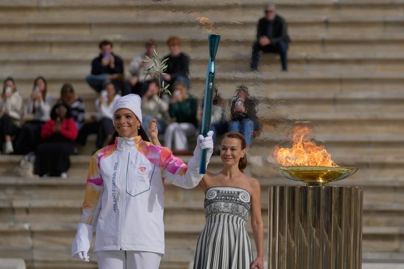 La jugadora de waterpolo griega Elena Xenaki enciende el pebetero durante la ceremonia de entrega de la llama olímpica para los Juegos de Invierno de Milán-Cortina 2026, en el estadio panatenaico, Atenas, Grecia, el 4 de diciembre de 2025. (AP Foto/Thanassis Stavrakis)